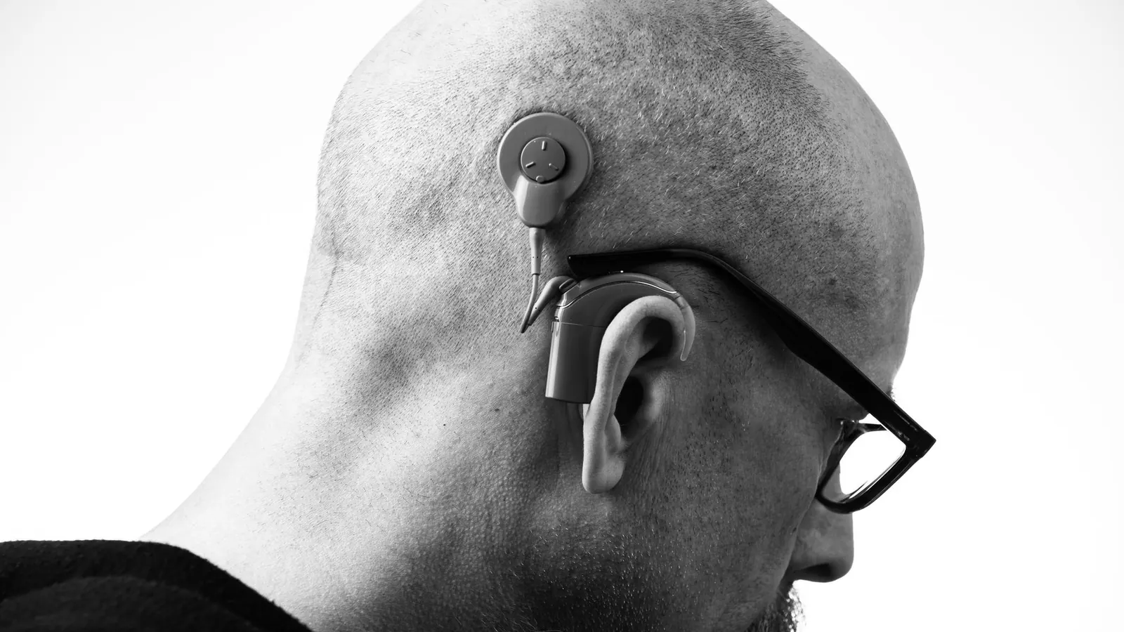 Homem usando aparelho auditivo discreto atrás da orelha