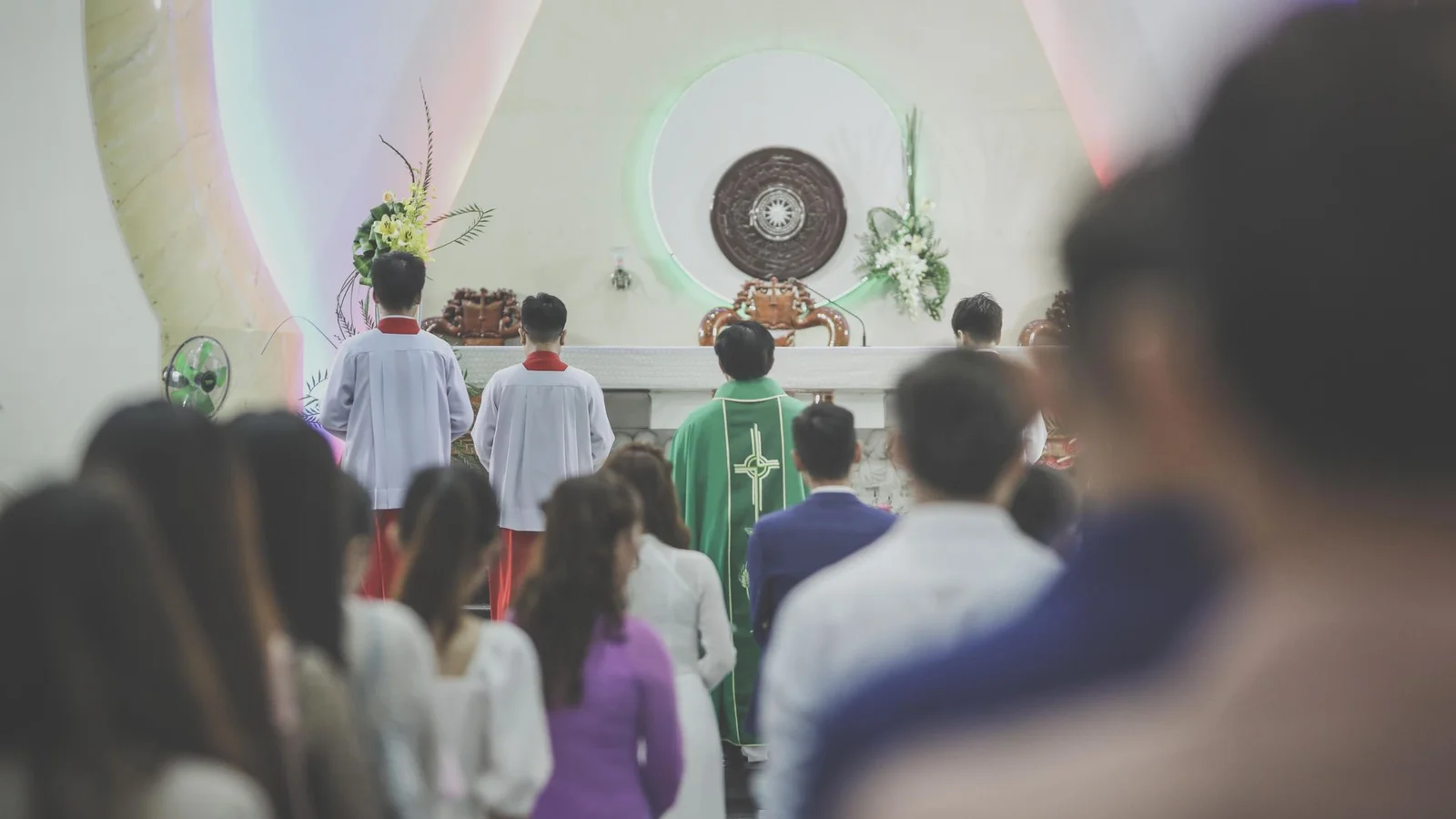 Fiéis em uma igreja com dificuldade de ouvir a missa devido à acústica