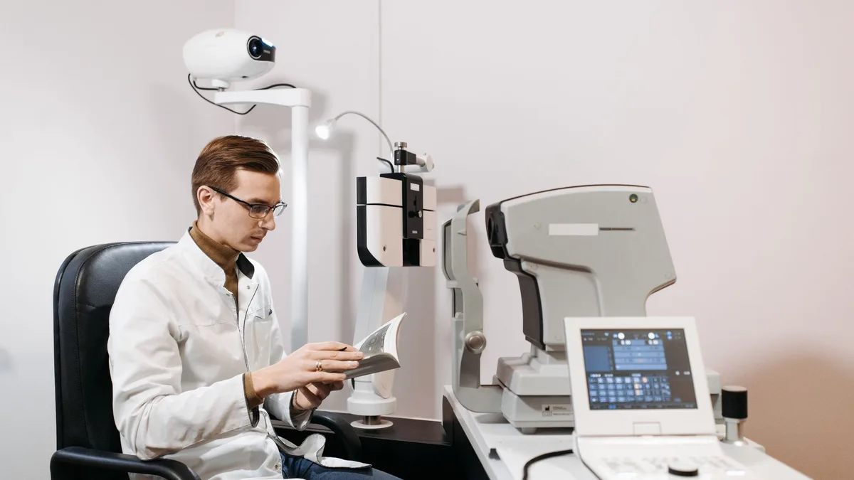Oftalmologista examinando olhos de paciente adulto com equipamento oftalmológico