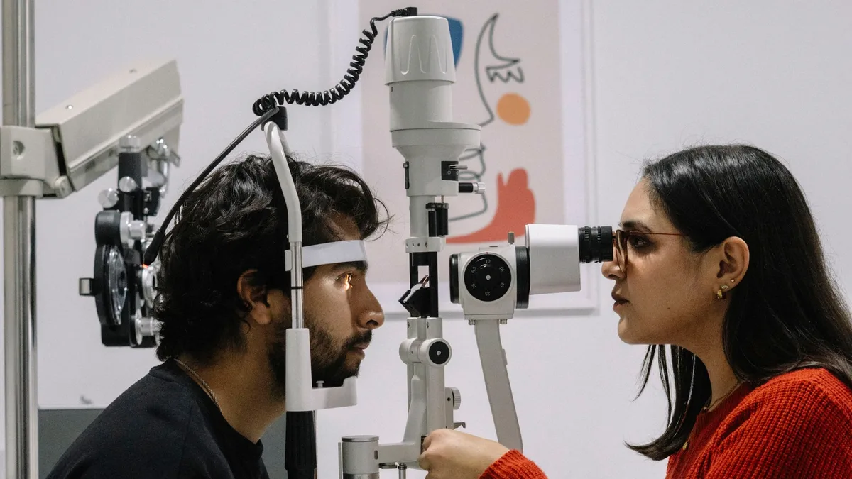 Homem adulto sentindo cansaço visual e visão dupla enquanto trabalha no computador