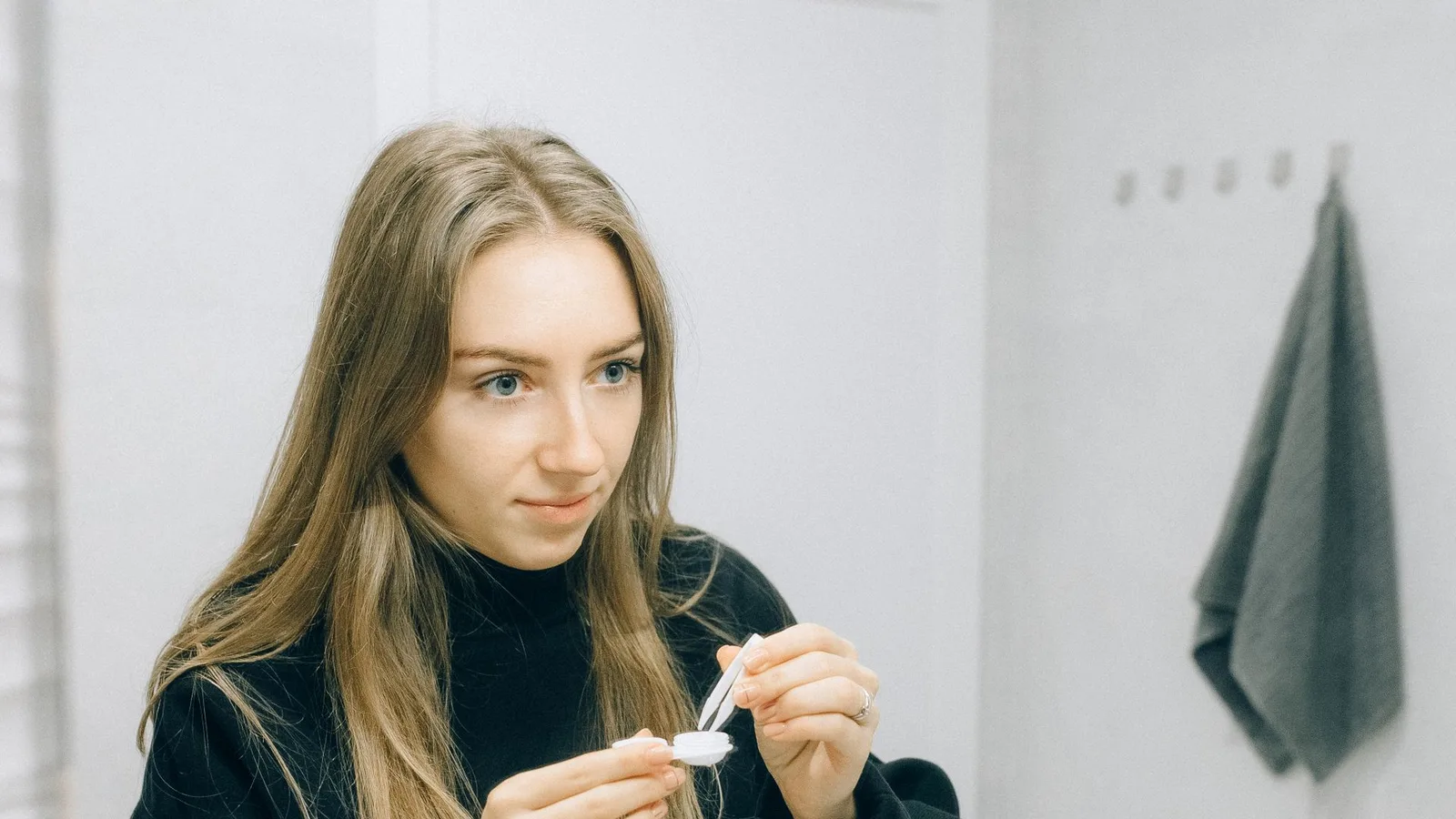Lentes de contato multifocais sendo colocadas nos olhos por uma mulher adulta