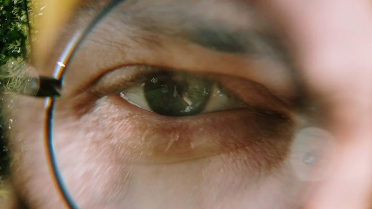 Close-up de homem olhando através de lente redonda de óculos