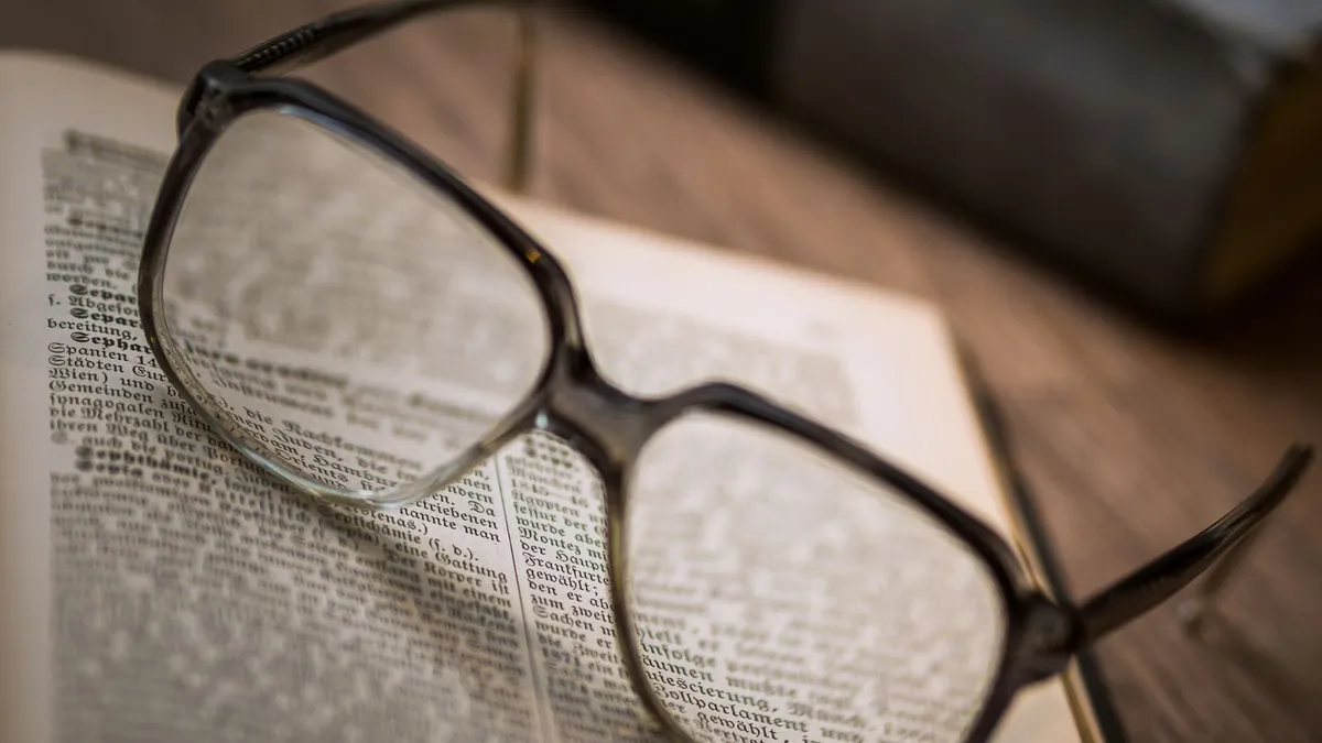 Óculos de grau apoiados sobre um livro aberto