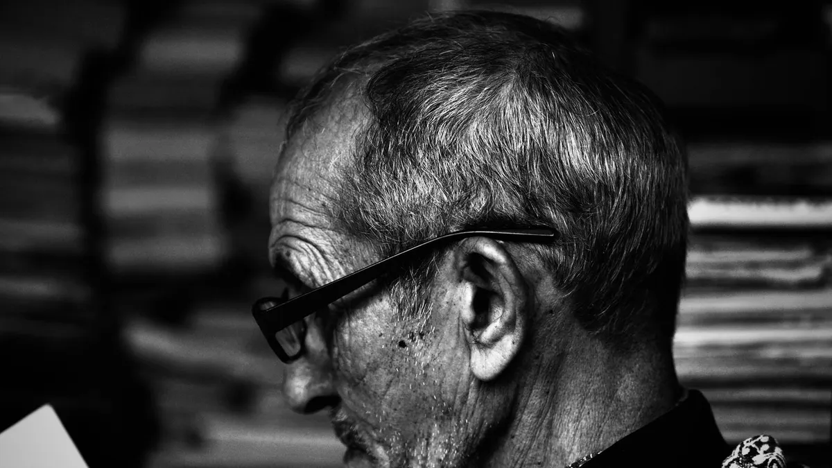 Senhor de óculos lendo um livro com atenção