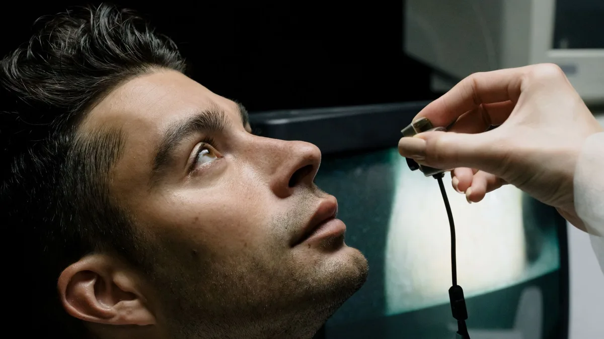 Profissional de saúde ocular orientando paciente homem durante consulta preventiva