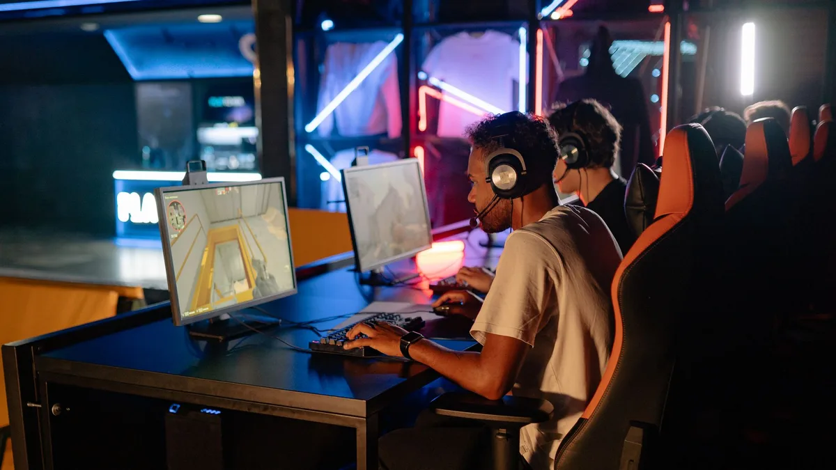 Estudante usando óculos com filtro de luz azul enquanto joga no computador