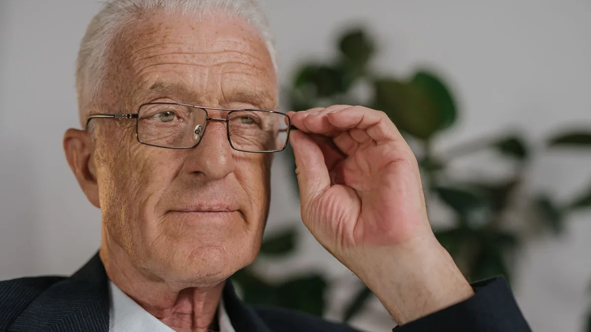 Profissional optometrista ajustando armação de óculos para um senhor
