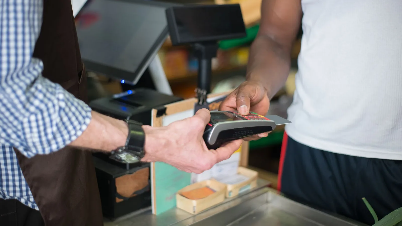 Cliente finalizando pagamento parcelado no cartão de crédito no balcão da Ótica em Fortaleza