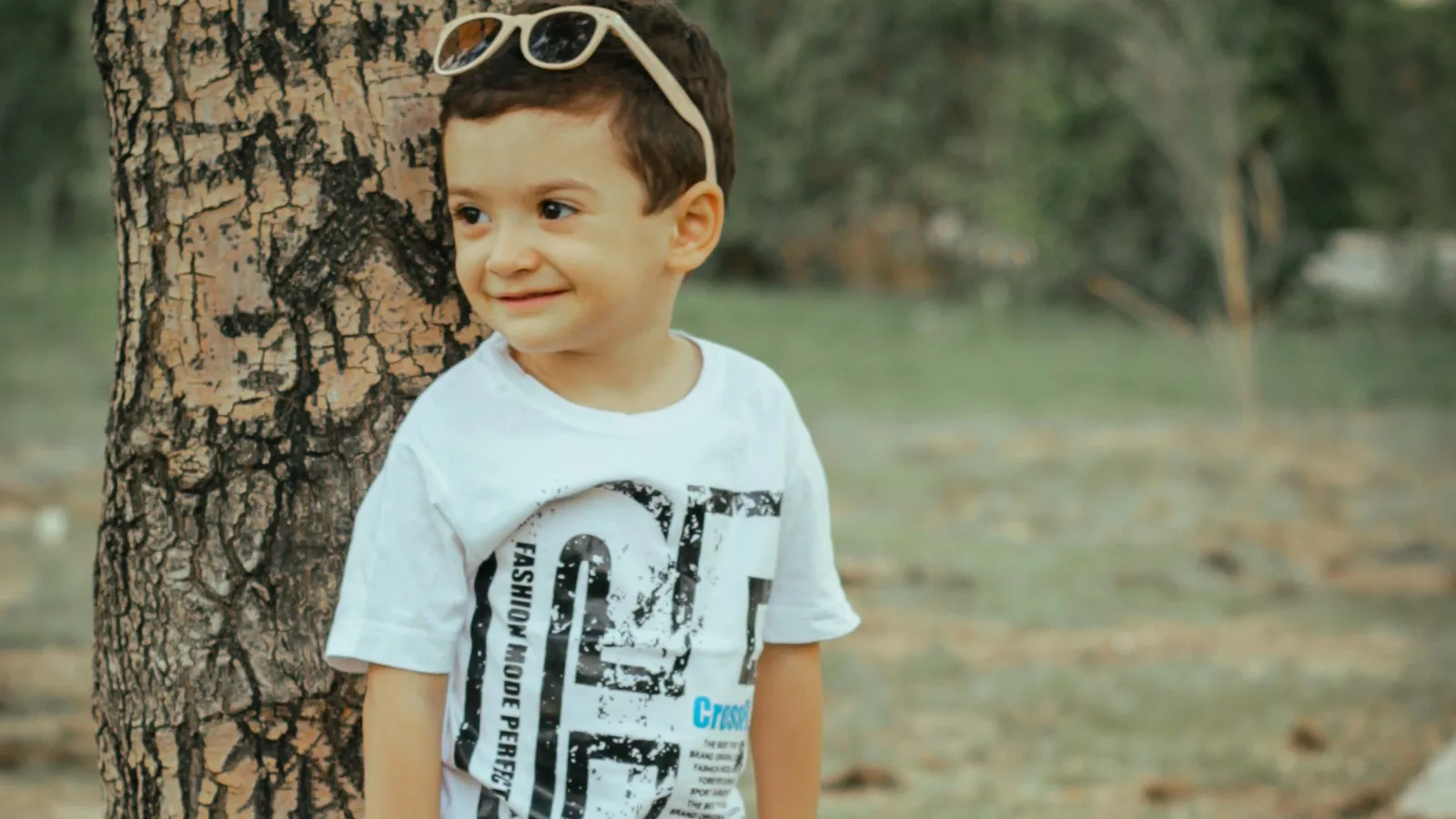 Criança sorridente experimentando óculos de sol infantil colorido