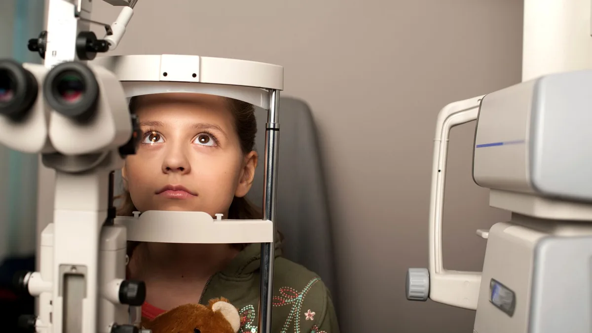 Criança pequena experimentando óculos infantil em ótica no Centro de Fortaleza
