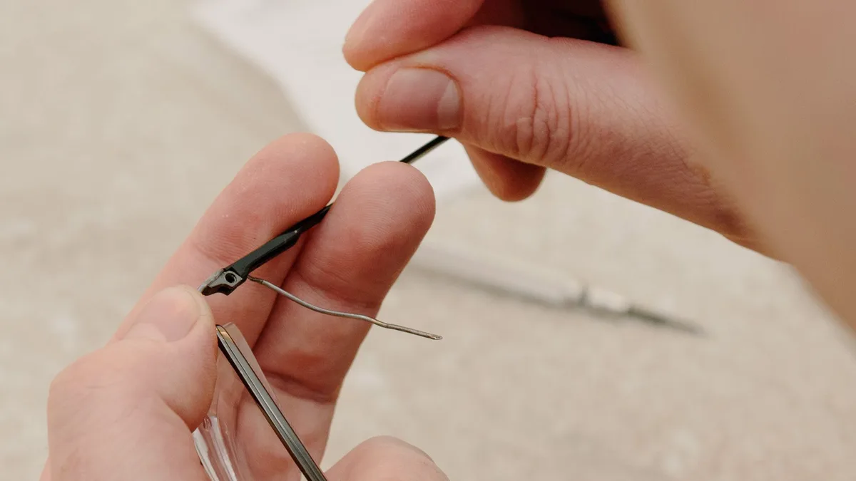 Profissional ajustando óculos de grau no rosto de cliente em ótica