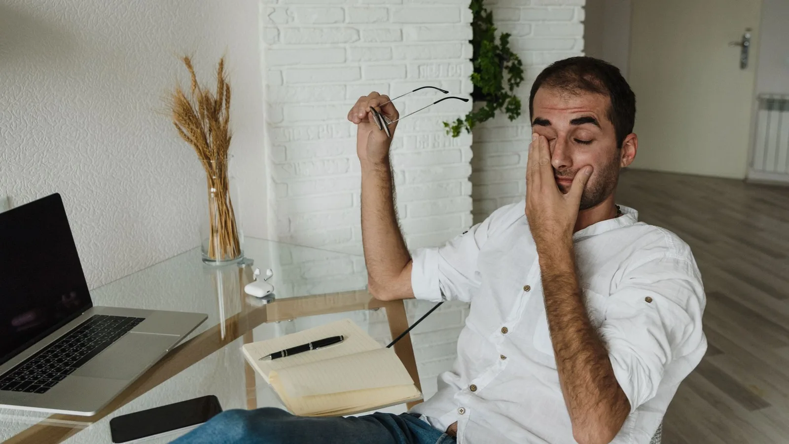Pessoa com fadiga ocular usando computador e sentindo desconforto nos olhos