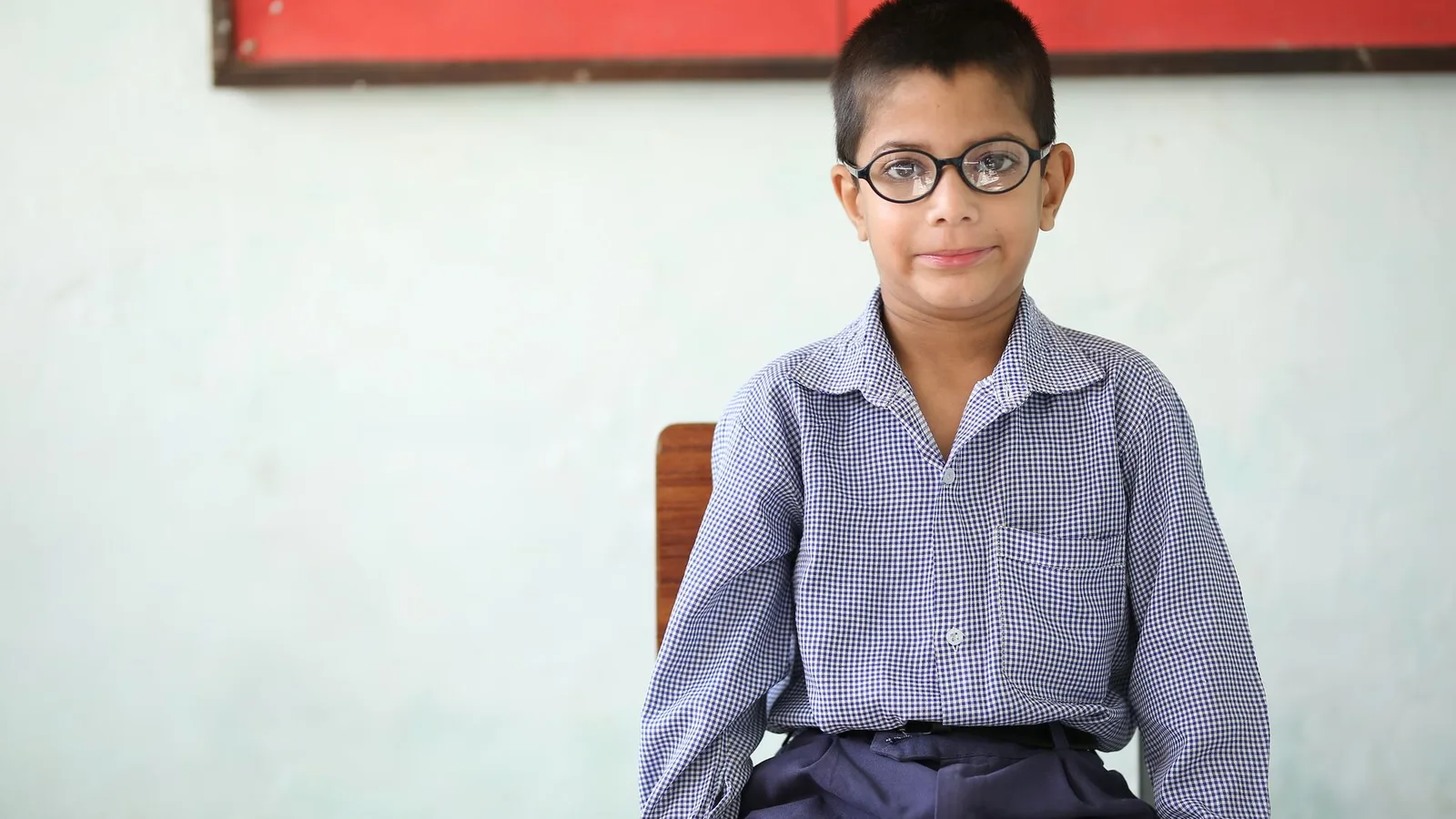 Criança fazendo exame de vista com óculos na volta às aulas